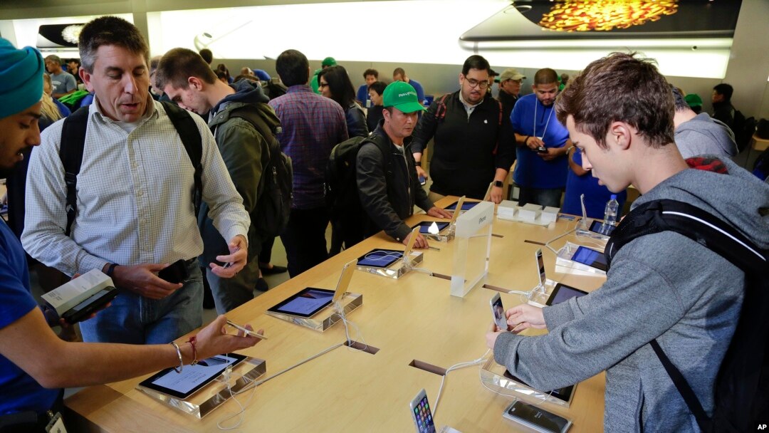 Visitors to the Apple store examine the iPhone 6 and 6 Plus, Sept. 19, 2014, in New York.