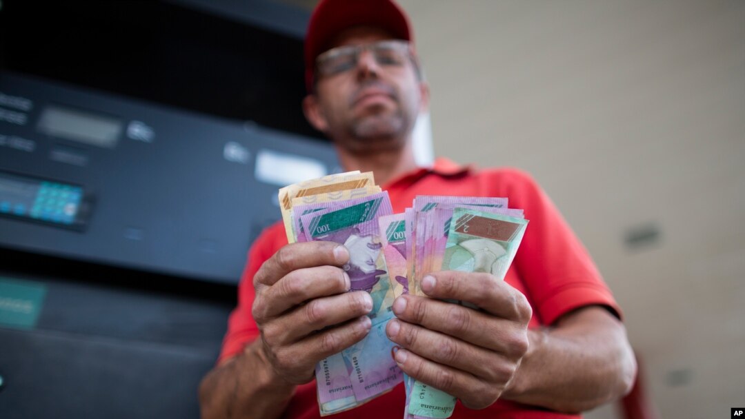 En esta foto de octubre de 2019, Orlando Godoy cuenta sus billetes de bolívares, la moneda local, en San Antonio de los Altos, en las afueras de Caracas, Venezuela.