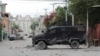 FILE - An armored police van sits in the area where gangs waged intense gun battles, shuttering main avenues and a municipal market in the downtown area of the capital, in Port-au-Prince, Haiti, July 27, 2022.