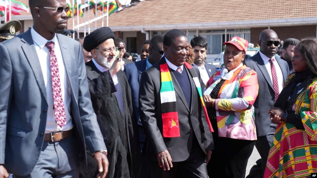 Iran's President Ebrahim Raisi waves while next to Zimbabwean President Emmerson Mnangagwa upon his arrival at Robert Mugabe International Airport in Harare, Zimbabwe, July 13, 2023.