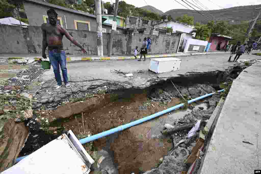 Residents look at a damaged drain in Shooters Hill, Jamaica, in the aftermath of Hurricane Beryl. Beryl powered towards Mexico and the Cayman Islands, threatening strong winds and a storm surge after battering Jamaica's southern coast.