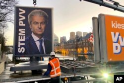 An election campaing poster of Geert Wilders' PVV party is removed in The Hague, Netherlands, Nov. 23, 2023.