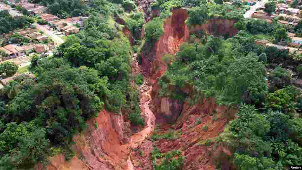 An aerial view shows a hole created by landslides over the past several years, and further enlarged after recent heavy rains, in Buriticupu in Maranhao state Brazil, March 28, 2023.