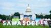People walk past a sign 'Sawasdee' or Hello in Thai during the Sawasdee DC Thai Festival 2023.