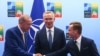 Turkey's President Recep Tayyip Erdogan, left, shakes hands with Sweden's Prime Minister Ulf Kristersson, right, as NATO Secretary-General Jens Stoltenberg looks on prior to a meeting ahead of a NATO summit in Vilnius, Lithuania, July 10, 2023. 