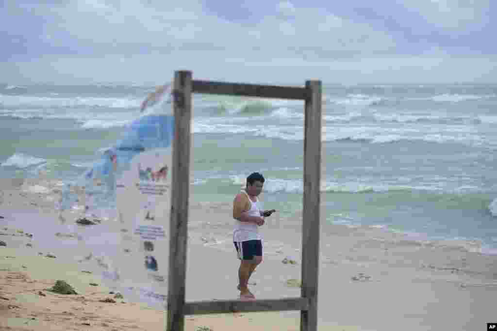 A man walks on the beach in the aftermath of Hurricane Beryl in Tulum, Mexico.