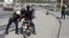 A police officer pats down a motorcyclist at a checkpoint in Port-au-Prince, Haiti, July 1, 2023. 