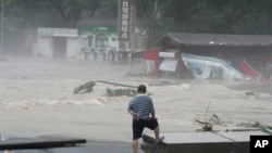 資料照：北京郊區妙峰山一名居民眼看著洪水淹沒街道。（2023年8月1日）