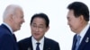 FILE - U.S. President Joe Biden talks with Japan's Prime Minister Fumio Kishida and South Korean President Yoon Suk Yeol, right, ahead of a trilateral meeting on the sidelines of the G7 summit in Hiroshima, Japan, May 21, 2023. 