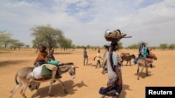 Sudanese families fleeing the conflict in Sudan's Darfur region make their way through the desert after they crossed the border between Sudan and Chad to seek refuge in Goungour, Chad, May 12, 2023.