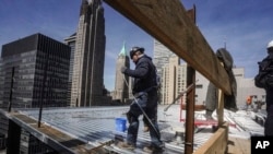 資料照片：2023年4月11日，建築工人在紐約曼哈頓金融區的一座高層建築上安裝屋頂。 （美聯社照片）