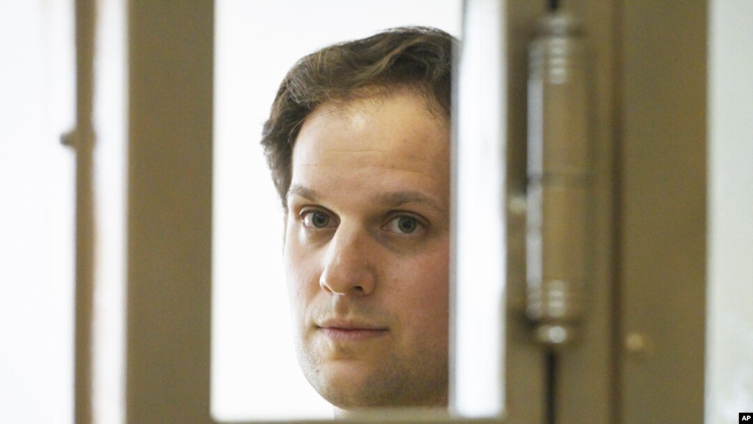 FILE - Wall Street Journal reporter Evan Gershkovich stands in a glass cage in a courtroom at the Moscow City Court in Moscow, Russia, June 22, 2023.