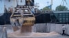 FILE - Workers load grain at a grain port in Izmail, Ukraine, on April 26, 2023.