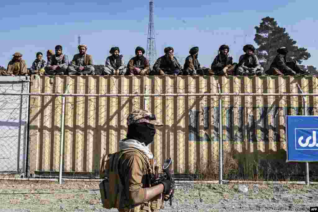 Taliban security personnel watch Afghan horsemen compete in a traditional Central Asian sport, buzkashi, during a friendly match between provinces at a field in Kabul.