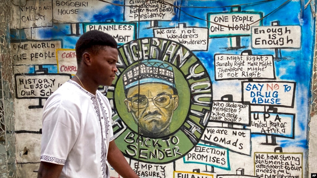 A man walks past a mural, painted for a previous election and showing incumbent President Muhammadu Buhari, in Lagos, Nigeria, Feb. 24, 2023. 