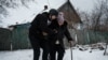 A volunteer Andrey (L), 38, helps Lydia Ivanovna, 62, to evacuate in Chasiv Yar, Feb. 15, 2023, amid the Russian invasion of Ukraine.