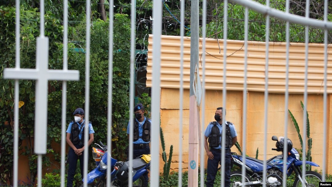 ARCHIVO - Agentes de la Policía vigilan afuera de una iglesia católica donde Rolando Álvarez, obispo de la Diócesis de Matagalpa y Estelí y crítico del presidente Daniel Ortega, se refugia alegando haber sido atacado por la policía, en Managua, el 20 de mayo de 2022. 