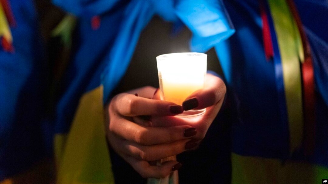 Demonstrator Sofia Koukhanova holds candles during a rally in support of Ukraine outside of the Russian Embassy in Washington, Feb. 24, 2023. 