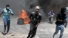 FILE — Protesters run for cover from tear gas fired by police during a protest against insecurity in Port-au-Prince, Haiti, Aug. 7, 2023. 