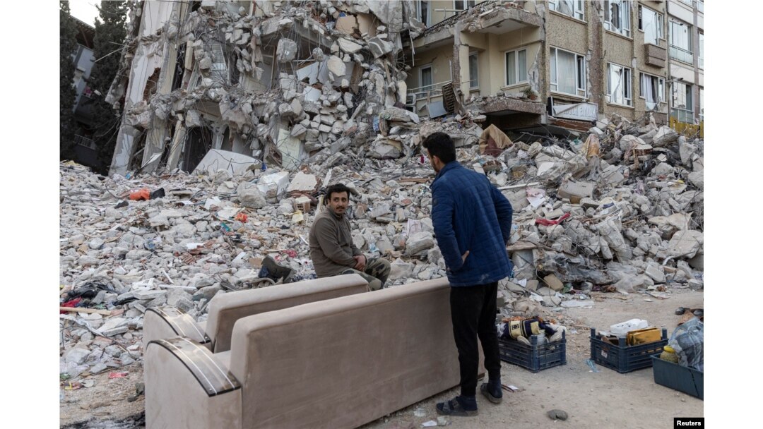 Survivors salvage belongings from their apartment building destroyed in a devastating earthquake, in Antakya, southeastern Turkey, Feb. 20, 2023.