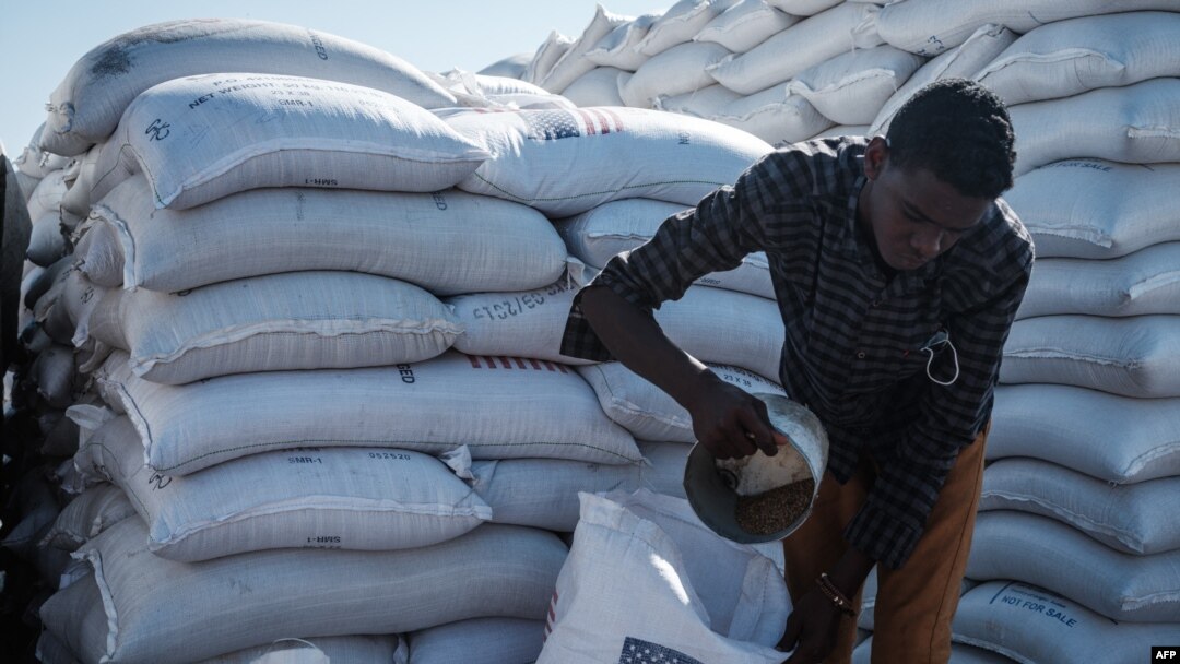 Mwanamume akigawa chakula kikiwa ni mchango kutoka USAID kwa wakimbizi wa Ethiopia, tarehe 2 Desemba 2020. Picha na Yasuyoshi CHIBA / AFP.
