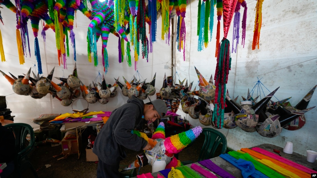 A worker makes a traditional Christmas "piñata" that will filled with fruit and candy at a family-run piñata-making business in Acolman, just north of Mexico City, Dec. 13, 2023.