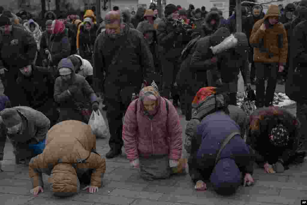 People pray at the Kyiv Pechersk Lavra monastery complex in Kyiv, Ukraine. The Russian invasion of Ukraine is reverberating in a struggle for control of a monastery complex, and the government said it's evicting the Ukrainian Orthodox Church from the complex, accusing it of pro-Russia actions and ideology.