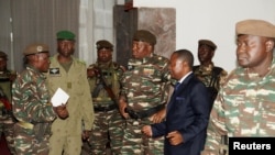 General Abdourahamane Tchiani, center, who was declared the new head of state of Niger by leaders of a coup, arrives to meet with ministers in Niamey, Niger, July 28, 2023. 