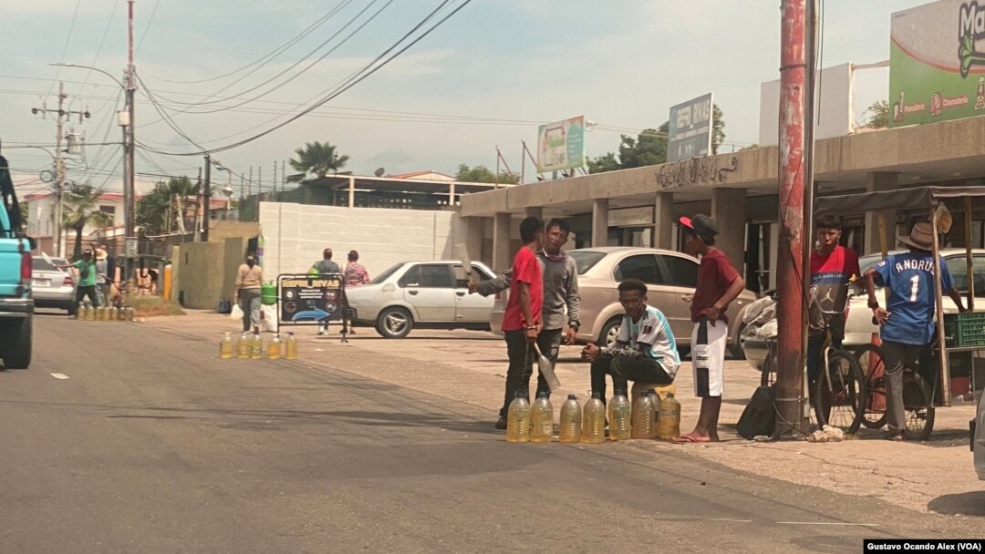 Revendedores de gasolina se instalan en varios puntos de una calle en Maracaibo, Venezuela, para ofrecer varios litros del combustible, el miércoles 14 de junio de 2023.