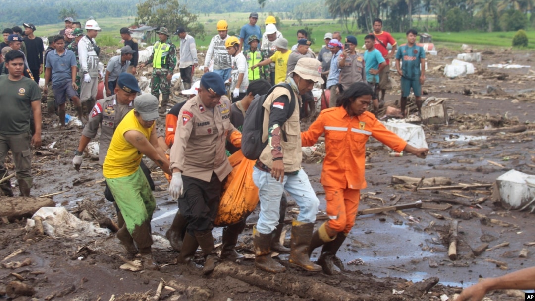 FILE - Rescuers carry the body of a victim of a flash flood in Tanah Datar, West Sumatra, Indonesia, on May 13, 2024.