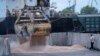 FILE - Workers load grain at a grain port in Izmail, Ukraine, April 26, 2023.