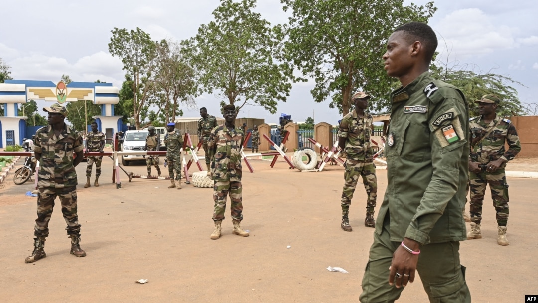 Nigerien soldiers stand guard as supporters of Niger's coup leaders gather for a demonstration in Niamey on Aug. 11, 2023, near a French airbase in Niger. 