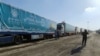 An Egyptian volunteer walks next to trucks carrying humanitarian aid from Egyptian NGOs for Palestinians, as they await for the reopening of the Rafah crossing at the Egyptian side to enter Gaza, in Rafah, Egypt, Oct. 19, 2023.