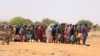 FILE - Sudanese refugees stand in line to receive food aid near the border between Sudan and Chad, in Koufroun, Chad, May 9, 2023.