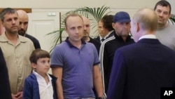 FILE - A man identified as Pablo Gonzalez (2nd-L with beard) listens as Russian President Vladimir Putin, right, speaks to released prisoners upon their arrival as part of an exchange, at Vnukovo airport outside Moscow, Russia, Aug. 1, 2024. (Gavriil Grigorov, Sputnik, via AP)