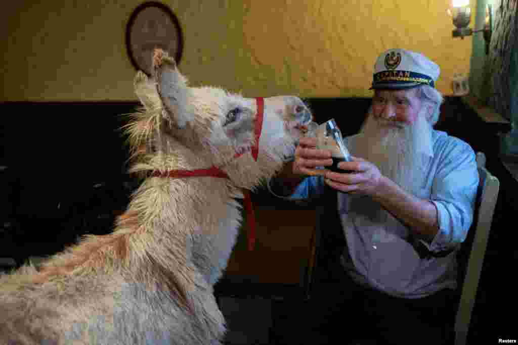  A donkey called Holly licks Guinness offered by Pake diskin, 72, in Mee's Bar in Kilkerrin, Ireland, July 4, 2023. The pub was featured as JJ Devine's Public House in Martin McDonagh's film 'The Banshees of Inisherin'. It was later savaged by the Mee family and is now open for business. 