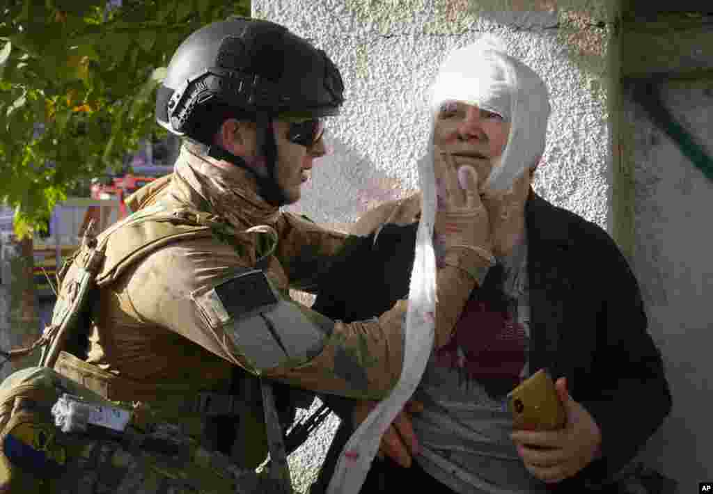 An injured woman receives medical treatment at the scene of Russian shelling, in Kyiv, Ukraine, Oct. 10, 2022. Multiple explosions rocked Kyiv following months of relative calm in the Ukrainian capital.