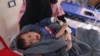 A woman holds her baby during treatment at a recently opened medical center for cholera cases in the Syrian town of Darkush, on the outskirts of the rebel-held northwestern province of Idlib, Oct. 22, 2022.