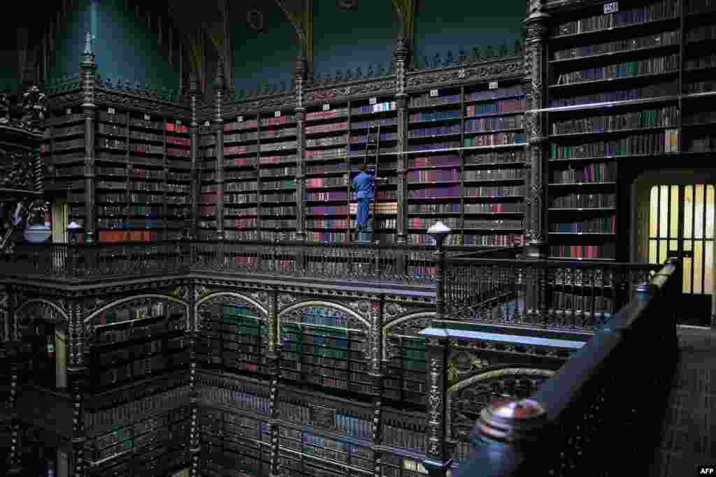 Employee Jeferson Deodata da Silva selects a book from the shelves of the Royal Portuguese Cabinet of Reading in Rio de Janeiro, Brazil, Nov. 19, 2018.