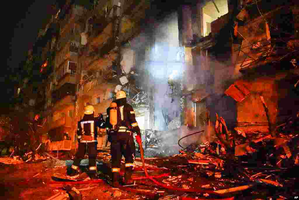 Firefighters inspect the damage at a building following a rocket attack on the city of Kyiv, Ukraine, in this handout photo taken from video released by Ukrainian Police Department Press Service.