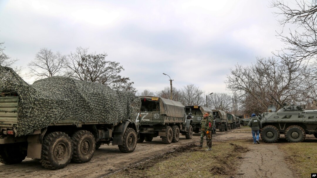 A convoy of military trucks remains parked on a street in Mykolaivka, Donetsk region, territory controlled by pro-Russian militiamen, Feb. 27, 2022, in eastern Ukraine.