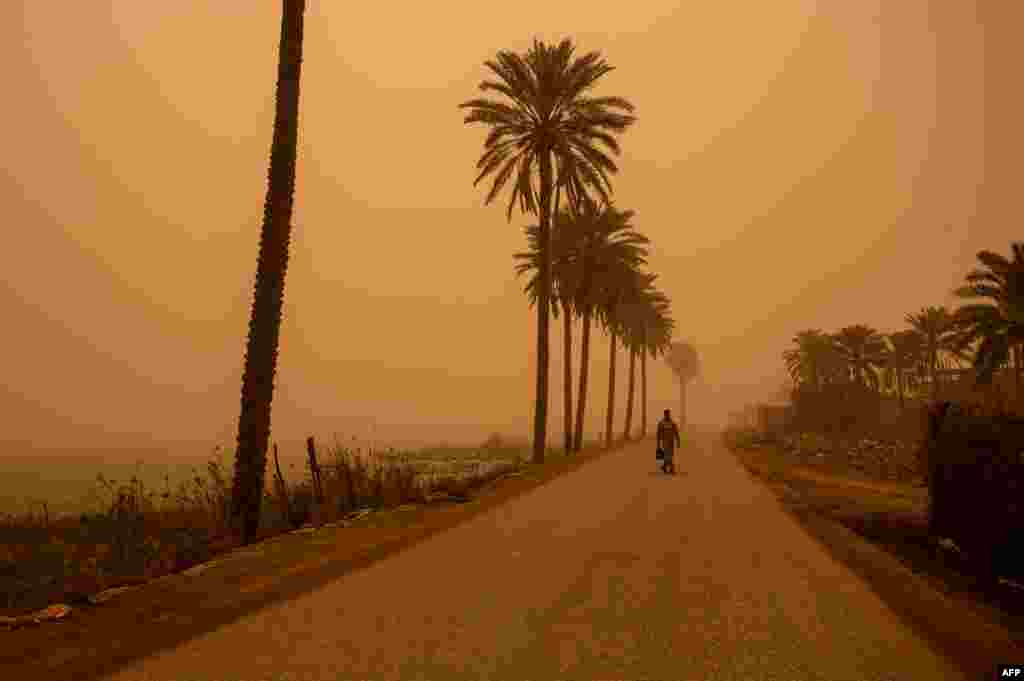 A man walks along a road during a sand storm in Iraq's southern port city of Basra.