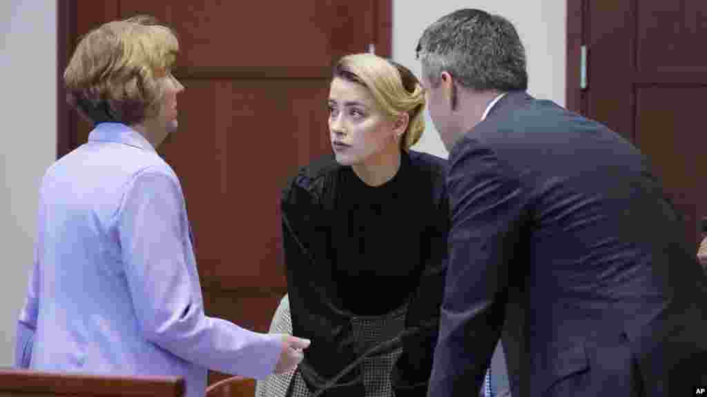 Actress Amber Heard talks to her attorneys in the courtroom at the Fairfax County Circuit Courthouse in Fairfax, Virginia. Actor Johnny Depp sued his ex-wife Amber Heard for libel after she wrote an op-ed piece in The Washington Post in 2018 referring to herself as a "public figure representing domestic abuse."