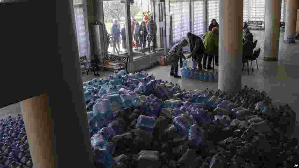 Local residents receive drinking water at a distribution center in Toretsk, eastern Ukraine, April 25, 2022. Toretsk residents have had no access to water for more than two months because of the war.