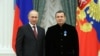 FILE - Russian President Vladimir Putin poses with TV anchor Vladimir Solovyov during an awards ceremony at the Kremlin in Moscow, Dec. 25, 2013.