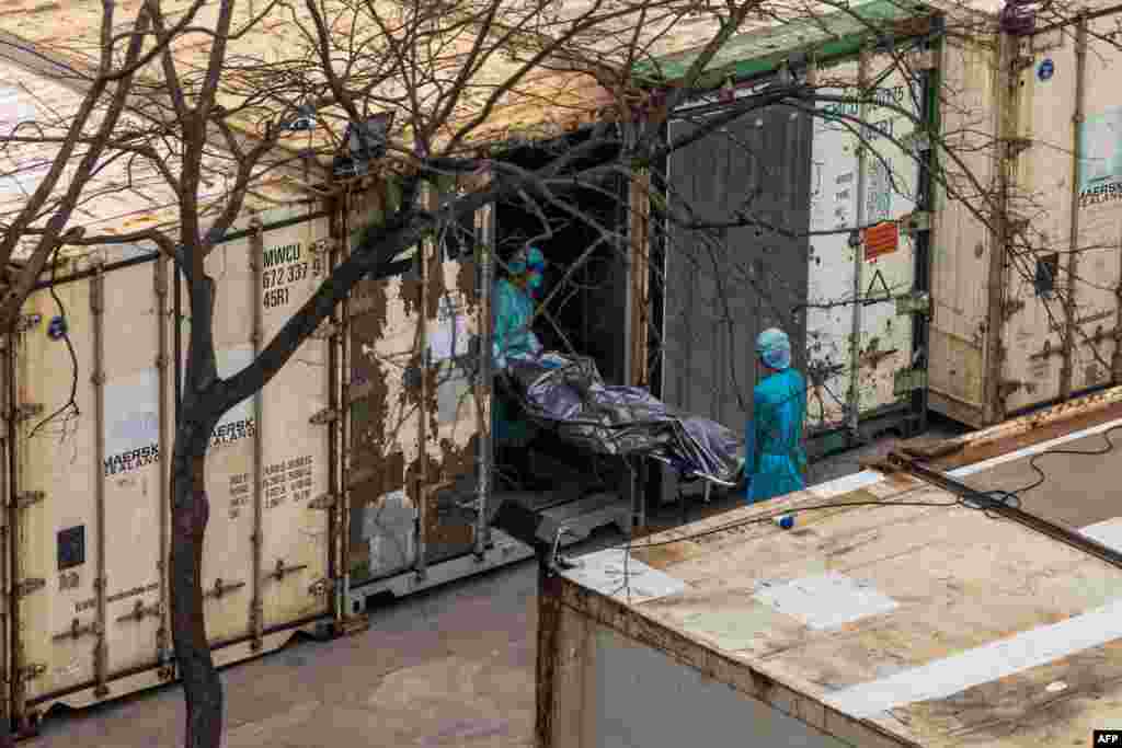 Workers move the body of a deceased person from a truck into a refrigerated container at the Fu Shan Public Mortuary in Hong Kong, amid the city's worst-ever COVID-19 outbreak.