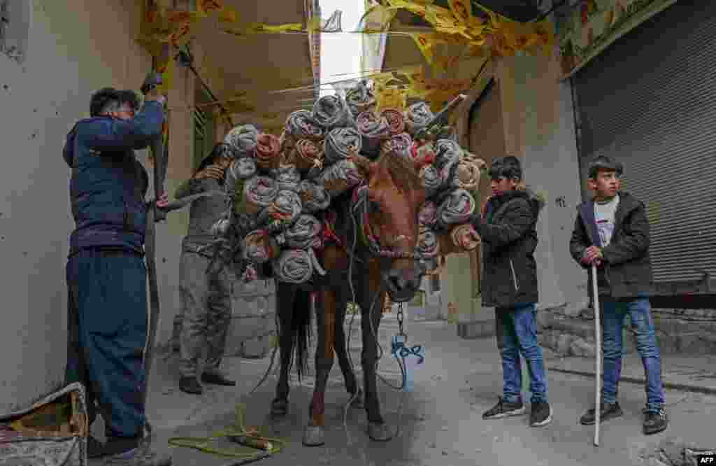 Men use a horse to transport torches during celebrations of the Persian new year Nowruz (Noruz) in the town of Akra, about 100 kilometers north of Arbil, in Iraq's northern autonomous Kurdish region.