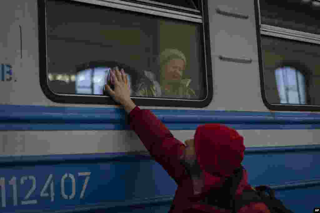 Displaced Ukrainians on a Poland-bound train bid farewell in Lviv, western Ukraine. The U.N. refugee agency says more than 3.5 million people have fled Ukraine since Russia's invasion, passing another milestone in an exodus that has led to Europe's worst refugee crisis since World War II.