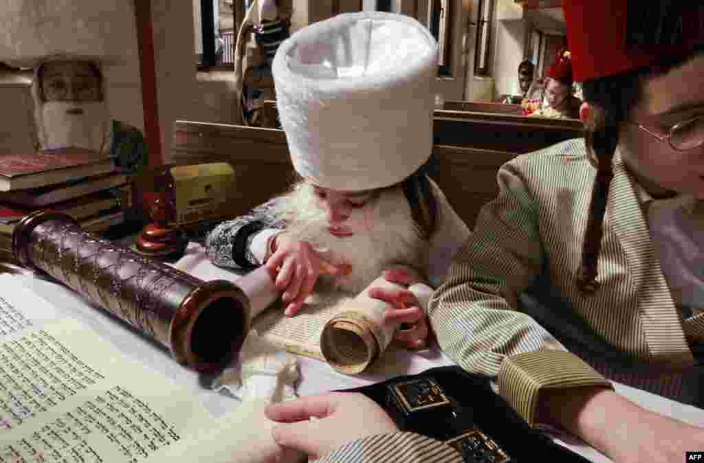 Ultra-Orthodox Jewish children in Purim costumes read the Biblical Book of Esther during the feast of Purim at a synagogue in the Israeli city of Bnei Brak.