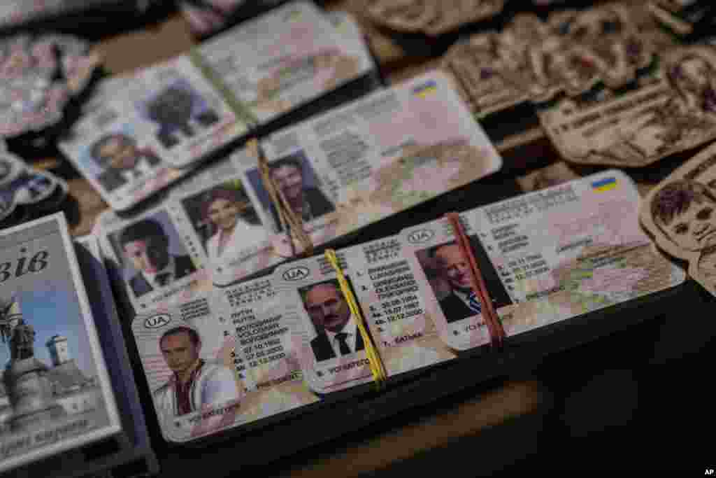 Fake IDs depicting Russian President Vladimir Putin, left, Belarusian President Alexander Lukashenko, center, and U.S. President Joe Biden for sale in a flea market in Lviv, western Ukraine.